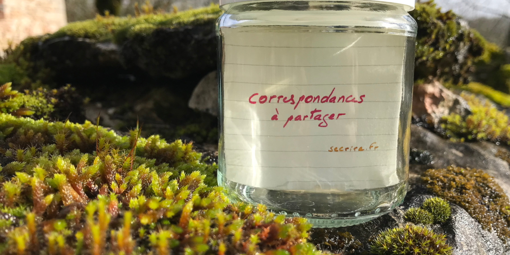 Message « correspondance à partager » dans un bocal en verre sur un mur
